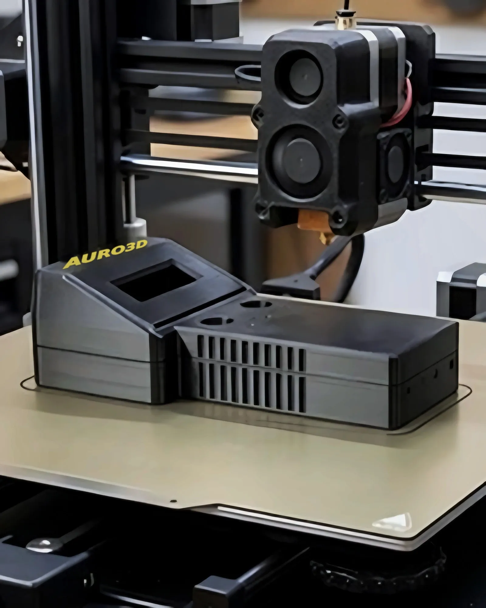 FDM 3D printer printing a black electronic enclosure