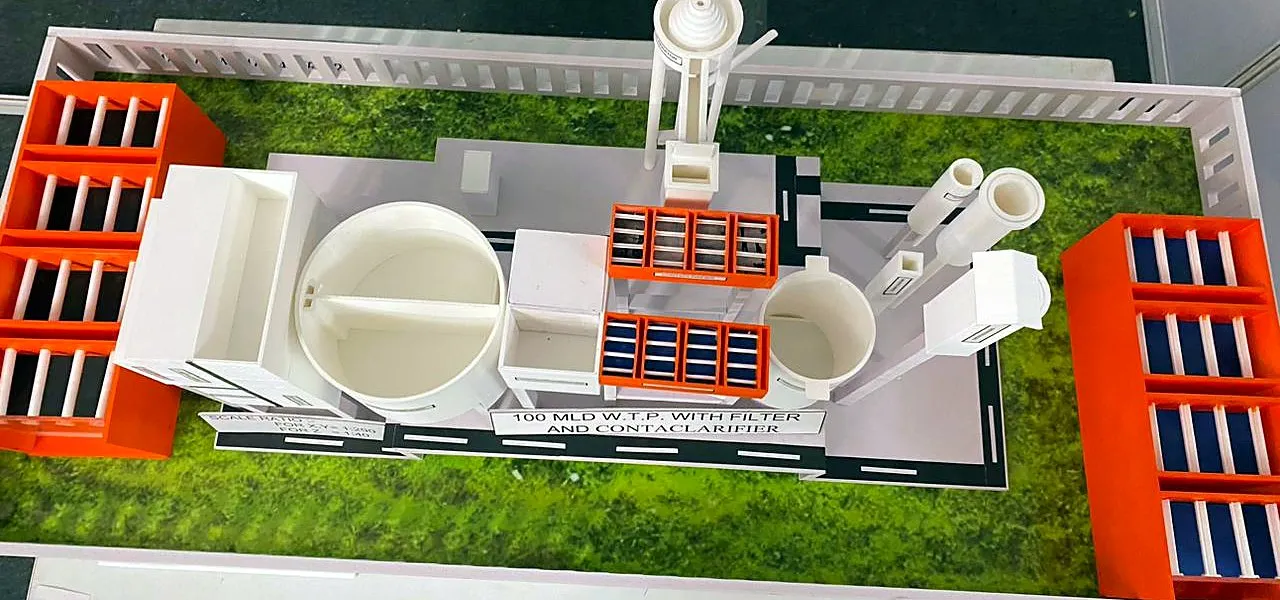 Top view of a 3D-printed water treatment plant scale model with filter beds, clarifiers, roads and a green landscaped base